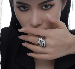 Close-up of chunky S925 sterling silver ring with organic fluid shape and mirror finish