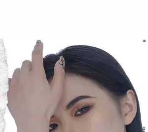 Close-up of a model wearing minimalist silver hoop earrings with creative white torn paper effect