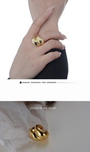 Close-up of a gold-plated multi-layered croissant ring with mirror-polished finish