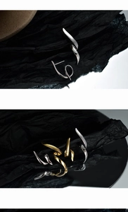 Macro detail of asymmetric wavy line S925 silver earrings in gold and silver finish
