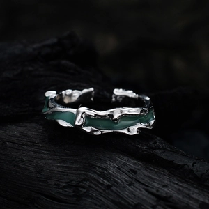 Irregular textured silver ring with green enamel, vintage adjustable design on wood