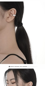 Detailed view of micro-paved silver ear cuff with sparkling diamonds on female ear