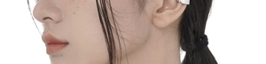 Macro detail of silver S925 sterling silver ear cuff with grid texture on model ear