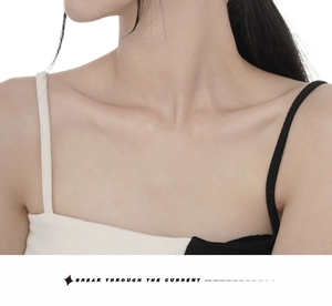 Macro shot of minimalist ribbed knit tank top with black and white asymmetric straps