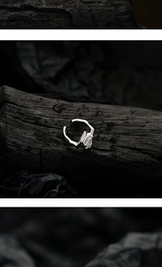 Macro shot of liquid metal silver ear cuff with sparkling teardrop zircon on dark charcoal