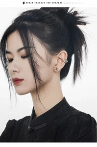 Detail of silver ear cuff and stud set with green gemstone in a modern Chinese style