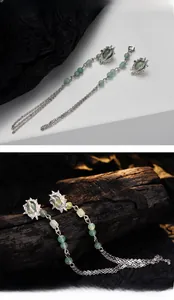 Detail of silver tassel earrings featuring green aventurine beads and sunburst studs