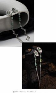 Detailed view of silver textured earrings with green aventurine and long tassel chains