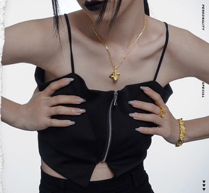 Dettaglio del set di gioielli dorati pieghettati con collana bracciale e anello chic