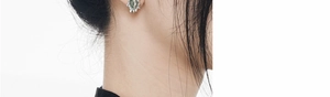 Macro shot of S925 silver thorn earrings with green aventurine stone detail
