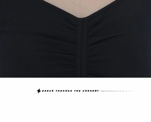 Detailed view of the V-neck black knit top featuring elegant ruched chest texture details