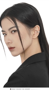 Detail of silver S925 ear cuff with irregular texture worn by a model in profile
