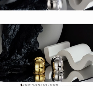 Close-up of polished gold and silver wide-band rings with futuristic streamlined design