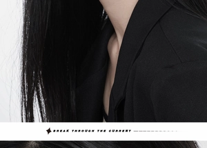 Close-up of black twill fabric suit jacket showing neckline tailoring and premium texture