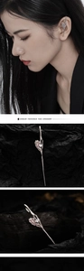 Detail of silver liquid metal ear cuff with pink gemstone on dark artistic background