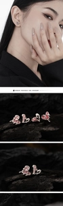 Dettaglio di orecchini a cuore rosa con texture argento e design stile lava