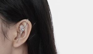 Detail of silver liquid metal heart ear cuff with long vertical spike on ear