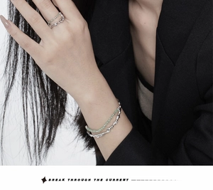 Detail of silver bamboo-style bangle and ring with green aventurine beads on model