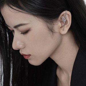 Silver liquid metal ear cuff featuring a purple gemstone accent on a model ear