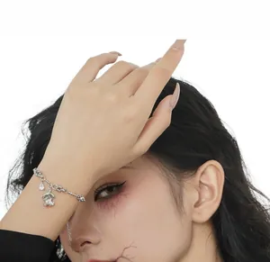 Detail of S925 silver ghost bracelet with zircon charms on model wrist