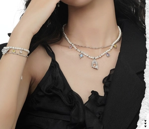 Detailed view of layered pearl necklace and bracelet set with colorful zircon charms