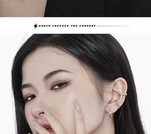 Detail of silver irregular ear cuffs with light blue zircons on a fashion model