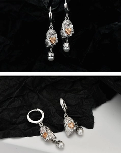 Detail of S925 sterling silver ghost earrings with amber heart stone and white pearl