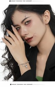 Close-up of S925 sterling silver ghost charm bracelet with zircons on model's wrist