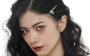 Close-up of S925 sterling silver ghost hat earrings on model with gothic makeup