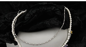 Close-up of double-layered necklace with white pearls and heart-shaped color gems