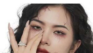 Close-up of Halloween face stickers with dark red crack texture on forehead and eyes