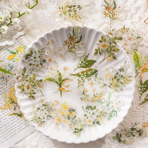 Adesivi per fiori in PET con mughetto e margherite e accenti dorati su pagine vintage