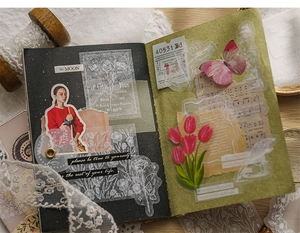 Detailansicht von Vintage-Spitzenaufklebern mit Blumen- und Porträtmotiven auf Journalen
