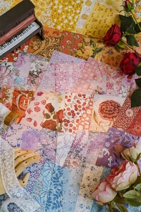 Dettaglio di carte decorative vintage con motivi floreali e botanici per scrapbooking