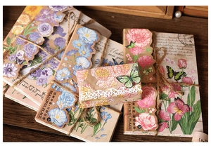 Close-up of vintage floral paper ephemera with scalloped edges and hemp rope on wood