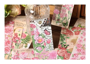 Vintage floral stickers with lace edges and butterfly designs on a rustic wooden table