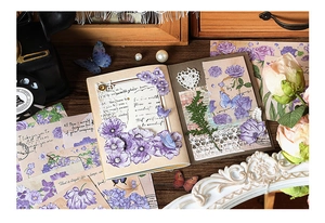 Close-up of vintage purple floral scrapbooking stickers and decorative paper set