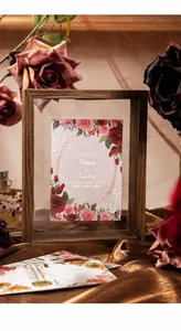 Dettaglio di una cornice in legno con cartoline floreali e carta decorativa in stile retrò