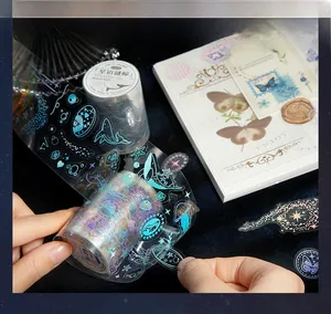 Detail of PET laser foil tape featuring whale and starry sky patterns for scrapbooking