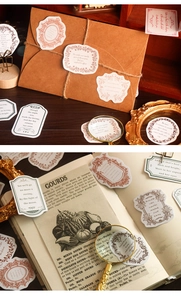 Dettaglio macro di adesivi vintage con citazioni letterarie per scrapbooking