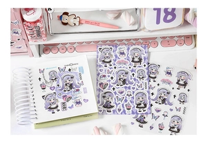 Macro detail of purple anime girl stickers set with binder notebook on a desk