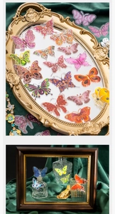 Artistic detail of vintage crystal butterfly stickers on a dark green velvet background