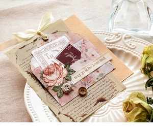 Detailansicht von Retro-Collagen-Umschlägen mit Rosenkarten und Seidenband-Dekor