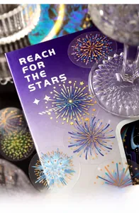 Macro shot of PET star and firework stickers with gold foil details on purple cover
