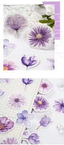Detail of purple watercolor floral stickers applied to a grid journal for DIY decoration
