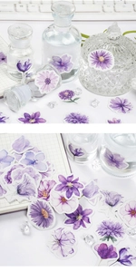 Macro detail of floral scrapbook stickers featuring purple daisies and tulips for DIY decor