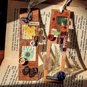 Vintage retro paper bookmarks set with dried flowers and buttons on an old book
