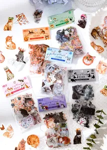 Artistic layout of vintage cat PET stickers on white textured surface with floral accents