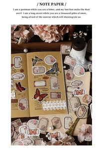 Detailed view of vintage butterfly and floral paper stickers on a wooden desk setup