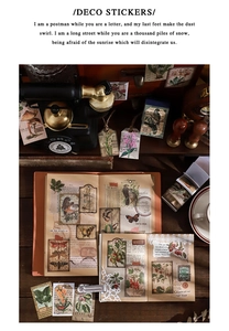Autocollants floraux vintage disposés sur un bureau en bois avec des accessoires